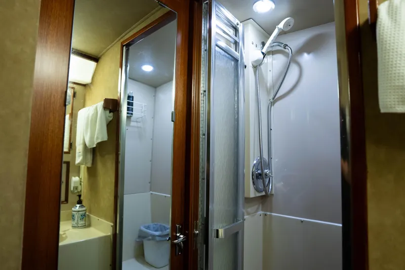 Slide: The Image of Bathroom interior of 1984 Bertram 35 Convertible yacht with shower and wooden accents. - 31