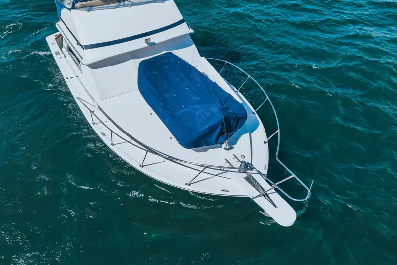 Slide: The Image of 1984 Bertram 35 Convertible boat on blue ocean water, aerial view. - 4