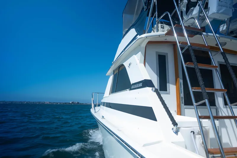 Slide: The Image of 1984 Bertram 35 Convertible yacht cruising on open water under clear blue sky. - 6