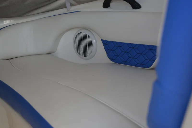 Slide: The Image of 2011 Yamaha AR210 boat interior with white and blue seating and speaker. - 13