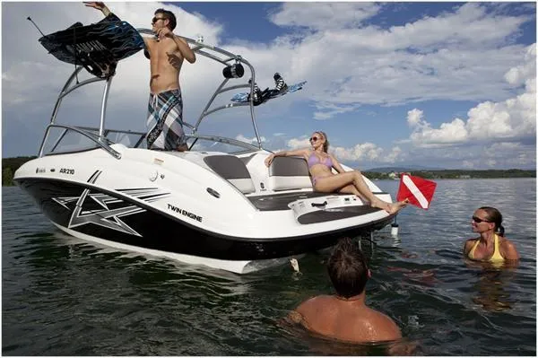 Slide: The Image of 2011 Yamaha AR210 boat on trailer, covered, parked outdoors. - 2