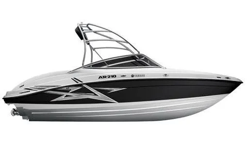 Slide: The Image of 2011 Yamaha AR210 boat covered on trailer, parked outdoors near industrial building. - 3