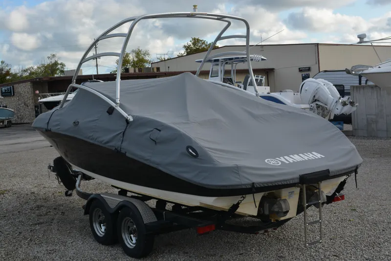 Slide: The Image of 2011 Yamaha AR210 boat covered, on a trailer, in a marina setting. - 4