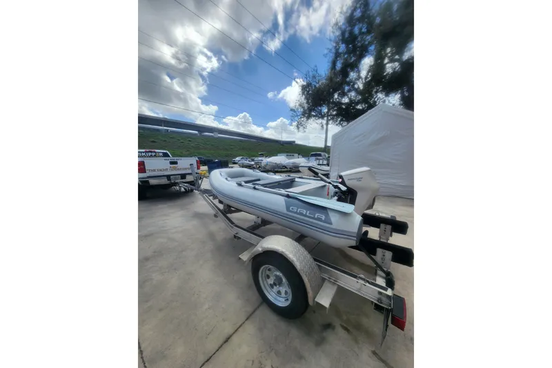 Slide: The Image of Inflatable boat Gala A300HD 2026 model, parked near a truck under a cloudy sky. - 4