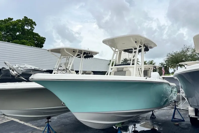 Slide: The Image of 2026 Key West 239 FS boat with a sleek turquoise hull, displayed outdoors. - 2