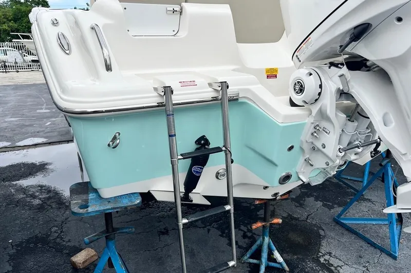 Slide: The Image of 2026 Key West 239 FS boat on stands, featuring a swim ladder and outboard motor. - 8