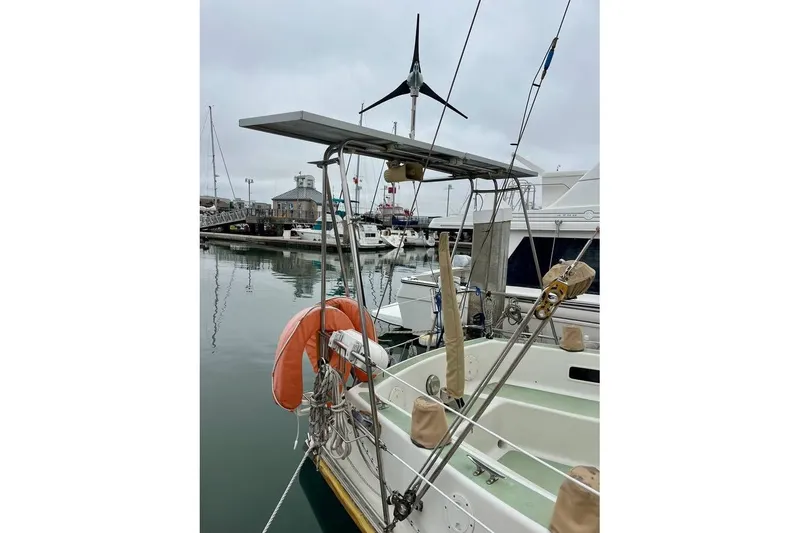 Slide: The Image of Sailboat Fortuna 37, 1989 model, docked with solar panel and wind turbine. - 5