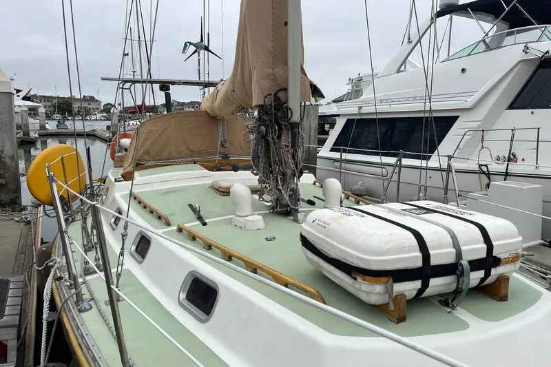 Slide: The Image of Sailboat Fortuna 37, 1989 model, docked at marina with life raft on deck. - 6