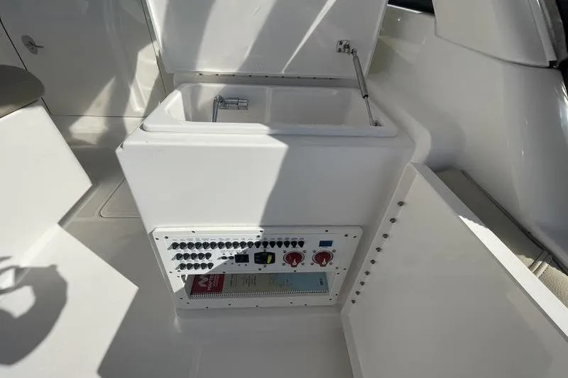 Slide: The Image of 2016 Pursuit DC 265 Dual Console boat interior with control panel and storage. - 20