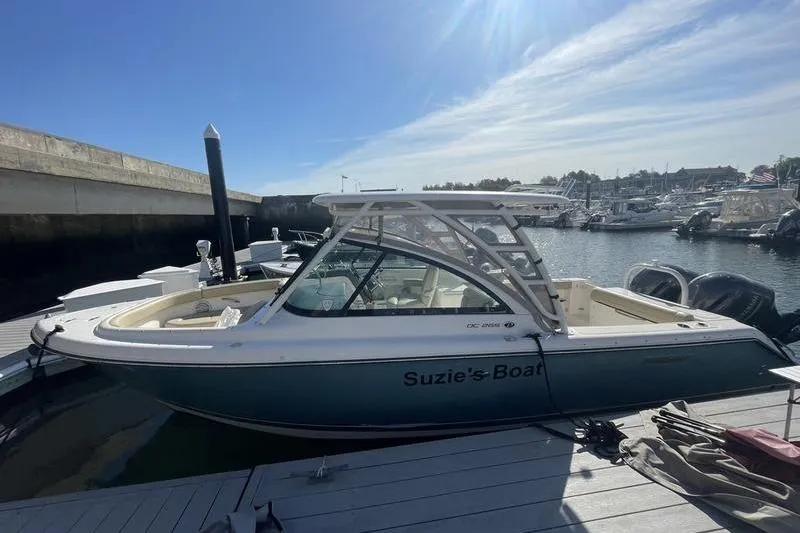 Slide: The Image of 2016 Pursuit DC 265 Dual Console boat docked at marina under clear sky. - 8