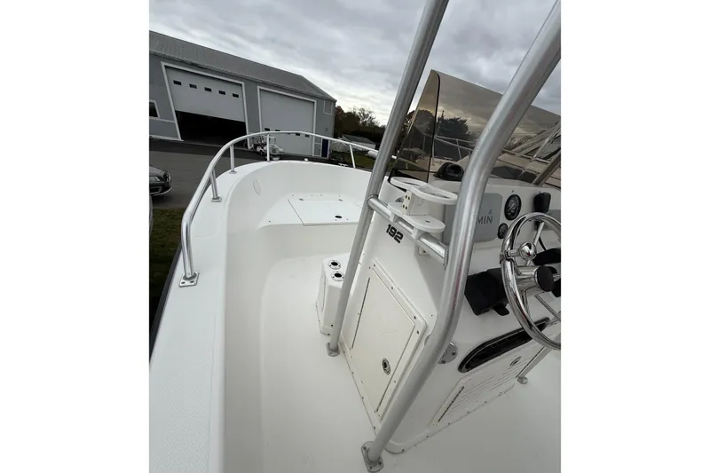 Slide: The Image of 2007 Mako 192 Center Console boat with steering wheel and controls, docked near a garage. - 13