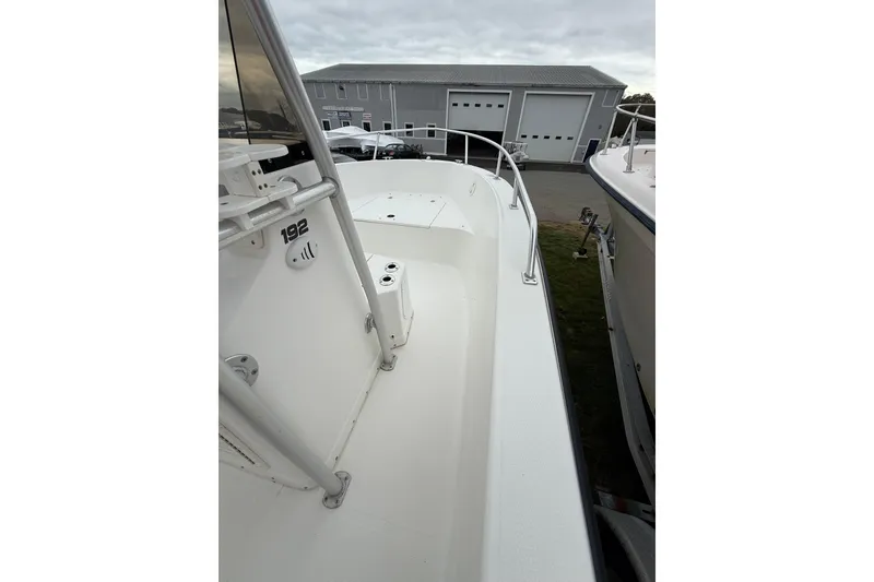 Slide: The Image of 2007 Mako 192 Center Console boat, white deck, docked near a large building. - 14