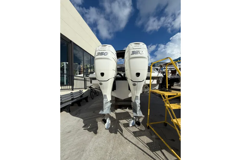 Slide: The Image of 2019 Cruisers Yachts 338 Outboard with twin 350 engines, docked under a clear sky. - 10