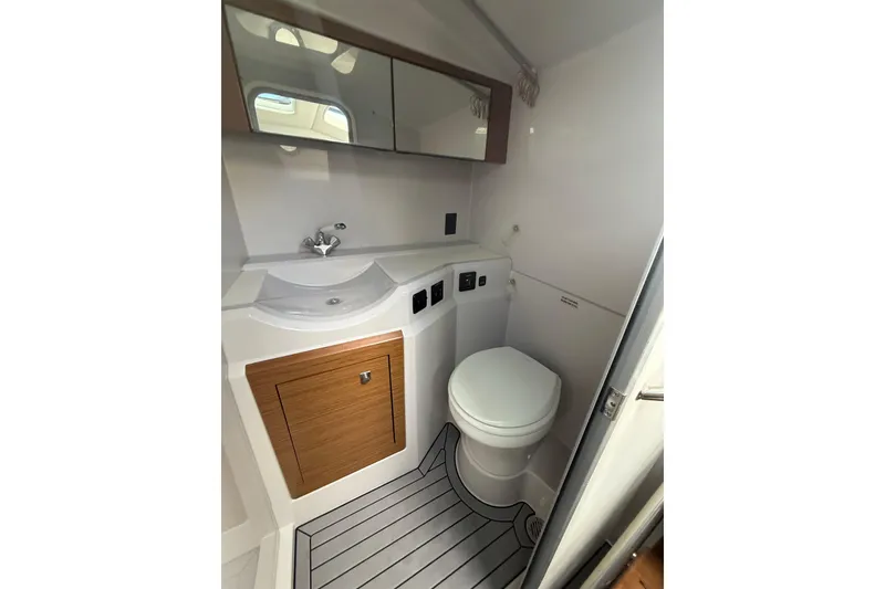 Slide: The Image of 2019 Cruisers Yachts 338 Outboard bathroom with sink, toilet, and wood accents. - 42