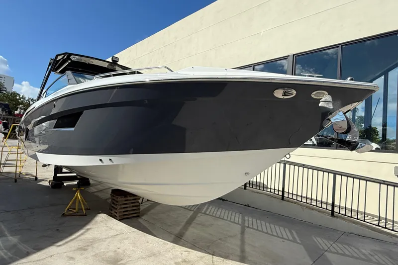 Slide: The Image of 2019 Cruisers Yachts 338 Outboard displayed outdoors, sleek design, black and white hull. - 7