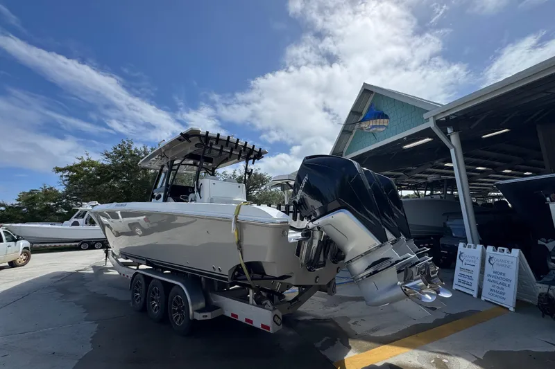 Slide: The Image of 2020 Fountain 38 Tournament Edition boat on trailer at marina under blue sky. - 12