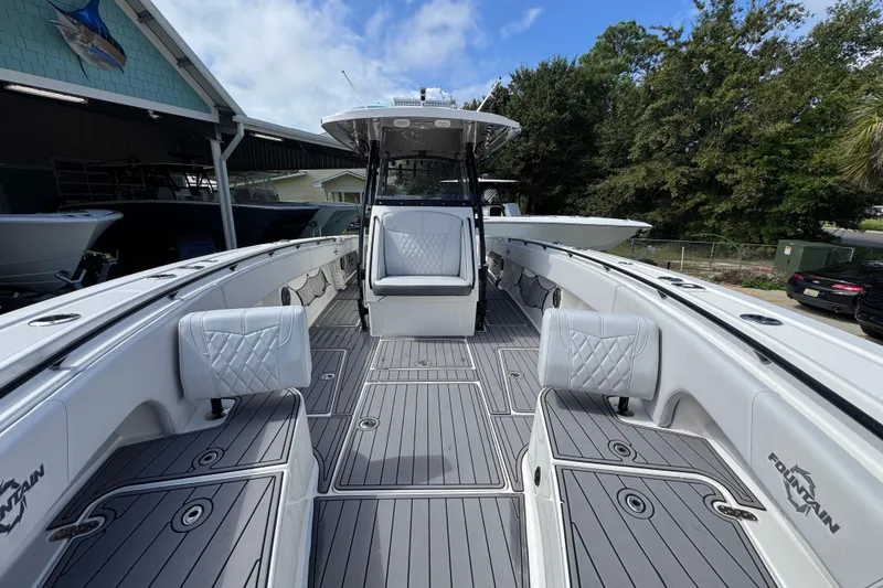 Slide: The Image of 2020 Fountain 38 Tournament Edition boat with spacious deck and seating, docked outdoors. - 20