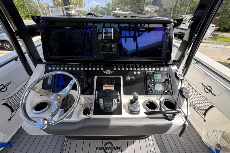 Slide: The Image of 2020 Fountain 38 Tournament Edition boat dashboard with steering wheel and navigation controls. - 28
