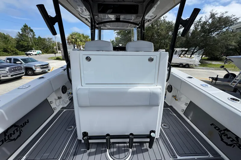 Slide: The Image of 2020 Fountain 38 Tournament Edition boat interior with seating and storage, parked outdoors. - 32