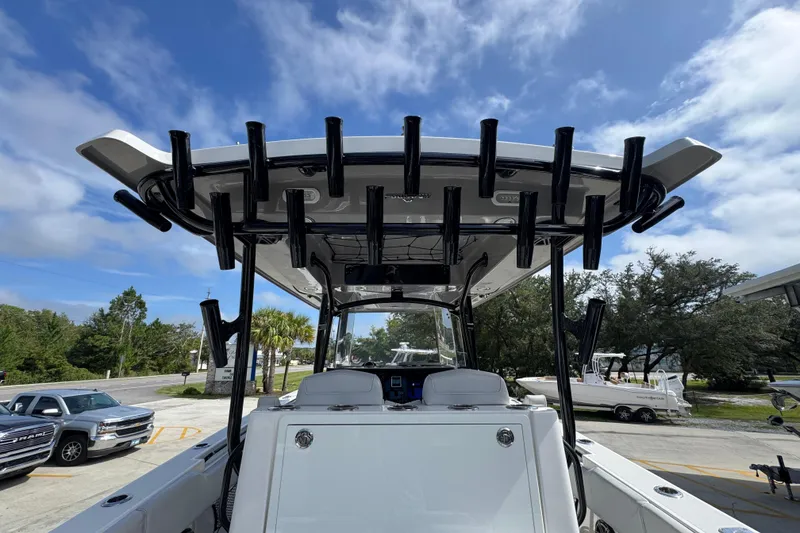 Slide: The Image of 2020 Fountain 38 Tournament Edition boat with rod holders, parked outdoors under a blue sky. - 34
