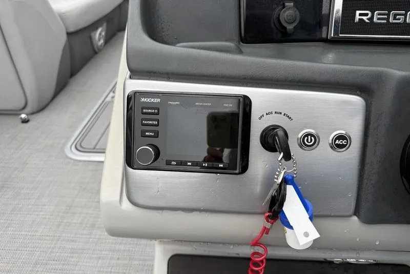 Slide: The Image of Control panel of 2023 Regency 250 DL3 boat with Kicker audio system and ignition keys. - 12