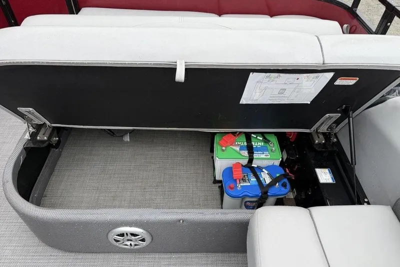 Slide: The Image of Storage compartment of 2023 Regency 250 DL3 boat with visible batteries and seating. - 16