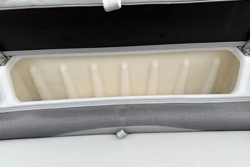 Slide: The Image of Open storage compartment in a 2023 Regency 250 DL3 boat, featuring cushioned seating. - 17