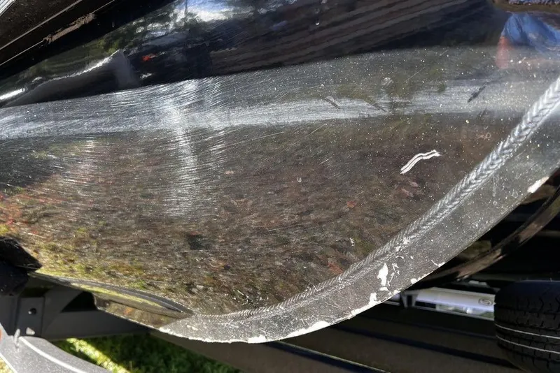 Slide: The Image of Close-up of 2023 Regency 250 DL3 boat hull with visible scratches and wear. - 31