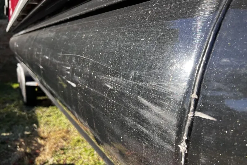 Slide: The Image of 2023 Regency 250 DL3 boat with visible scratches and wear on the black exterior. - 32