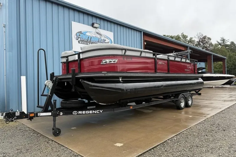 Slide: The Image of 2023 Regency 250 DL3 pontoon boat on trailer outside Foothills Marine building. - 33