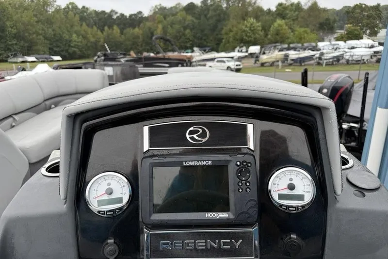 Slide: The Image of 2023 Regency 250 DL3 boat dashboard with Lowrance display and gauges, surrounded by seating. - 9