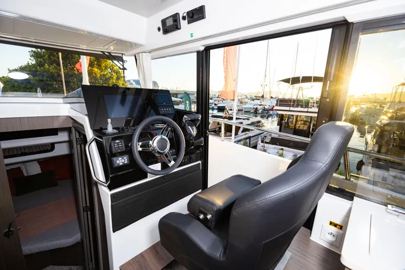Slide: The Image of 2026 Jeanneau NC 895 Sport Series 2 helm with modern controls and marina view. - 21