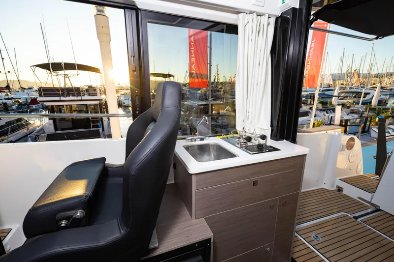 Slide: The Image of 2026 Jeanneau NC 895 Sport Series 2 interior with helm, sink, and marina view. - 22