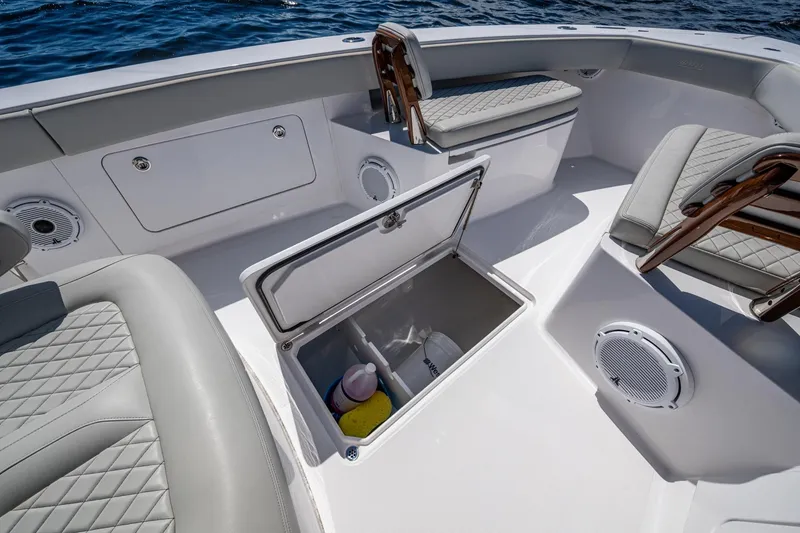 Slide: The Image of 2022 Jupiter 32 boat interior with open storage compartment and cushioned seating. - 13