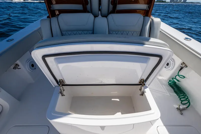 Slide: The Image of Open storage compartment on 2022 Jupiter 32 boat, with cushioned seating and ocean backdrop. - 22