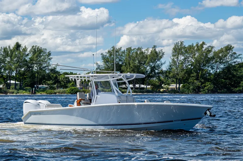 Slide: The Image of 2022 Jupiter 32 boat cruising on a sunny day with trees in the background. - 3