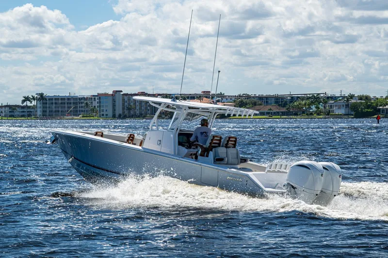 Slide: The Image of 2022 Jupiter 32 boat cruising on a sunny day with buildings in the background. - 30