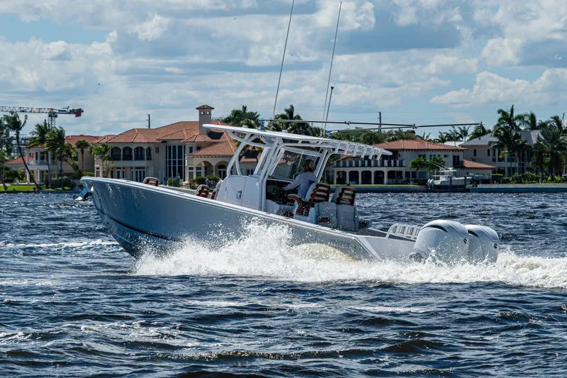 Slide: The Image of 2022 Jupiter 32 boat cruising on water near luxury waterfront homes. - 32
