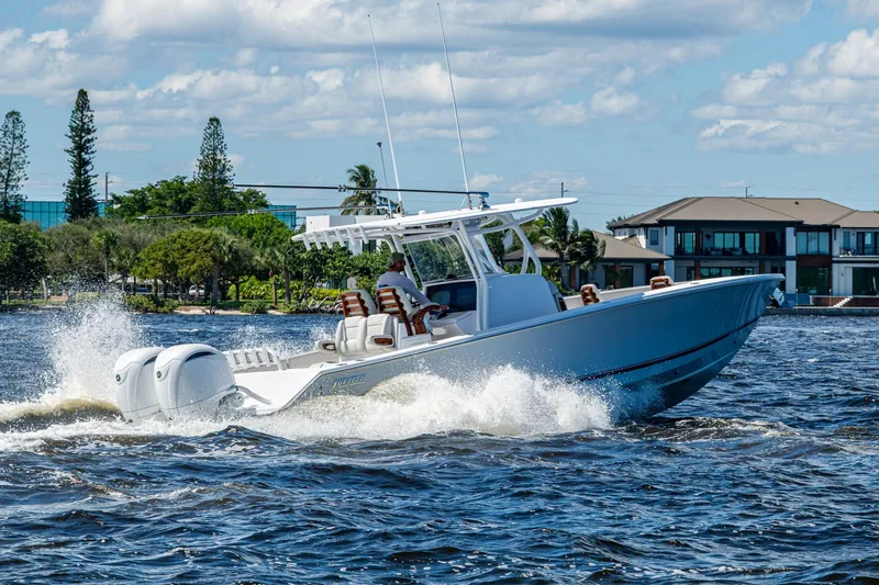 Slide: The Image of 2022 Jupiter 32 boat cruising on a sunny day near waterfront homes. - 33
