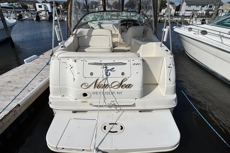 Slide: The Image of 2000 Sea Ray 240 Sundancer docked, featuring spacious seating and elegant design. - 2