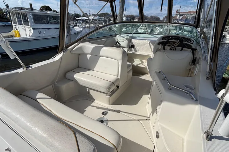 Slide: The Image of 2000 Sea Ray 240 Sundancer boat interior with white seating and steering wheel. - 3