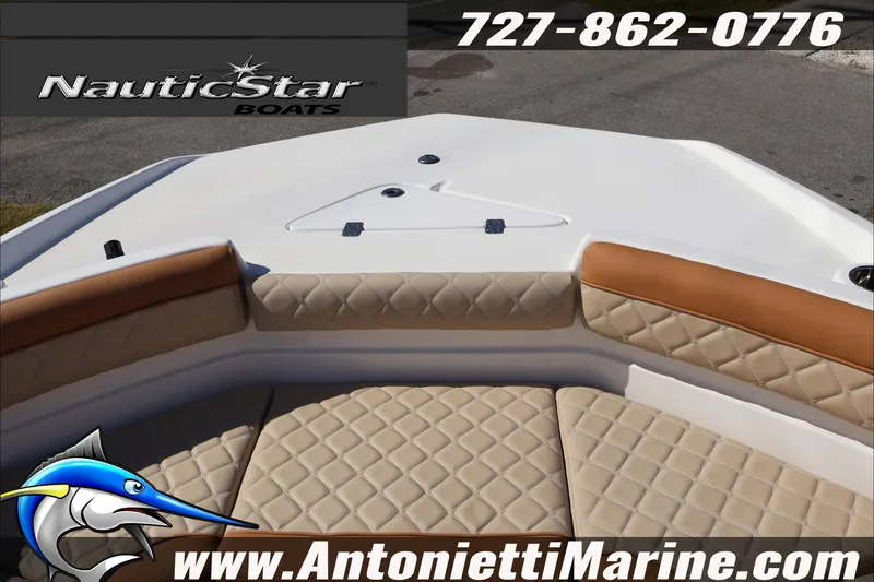 Slide: The Image of 2025 NauticStar 231 Hybrid boat interior with tan quilted seating, logo, and contact details. - 23