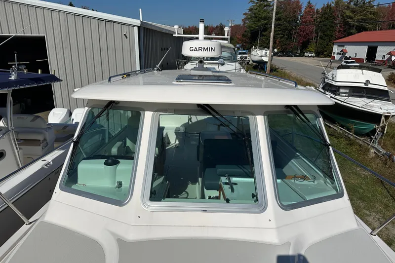 Slide: The Image of 2024 Back Cove 34O yacht bathroom with showerhead and porthole window. - 14