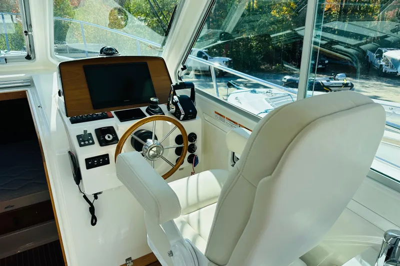 Slide: The Image of 2024 Back Cove 34O interior with modern kitchen, seating, and helm station. - 2