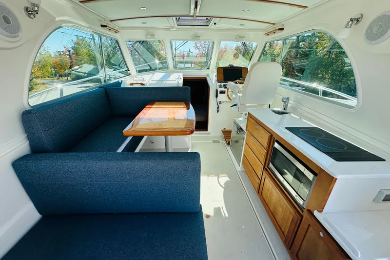 Slide: The Image of 2024 Back Cove 34O cabin interior with wooden finish and comfortable bedding. - 3