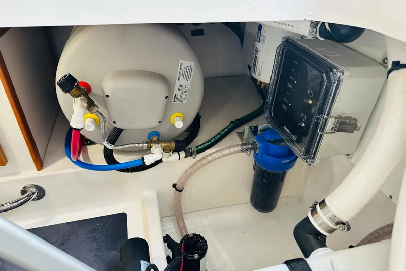 Slide: The Image of 2024 Back Cove 34O boat on stands, dual outboard engines, parked near trees and road. - 34