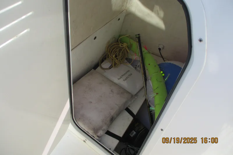 Slide: The Image of Storage compartment of 2018 NauticStar 22 XS Offshore boat with various items inside. - 13