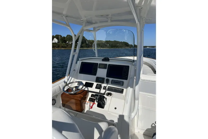 Slide: The Image of 2011 Regulator 34SS boat cockpit with steering wheel and navigation equipment on water. - 2
