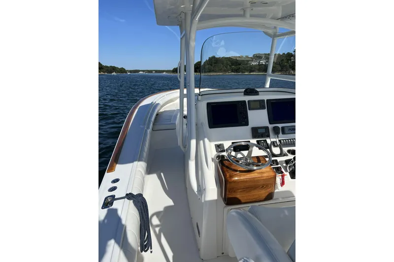 Slide: The Image of 2011 Regulator 34SS boat interior with steering console and navigation equipment on calm water. - 4