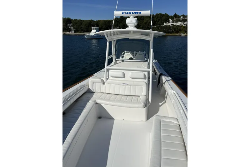 Slide: The Image of 2011 Regulator 34SS boat with white seating, docked on calm water. - 5